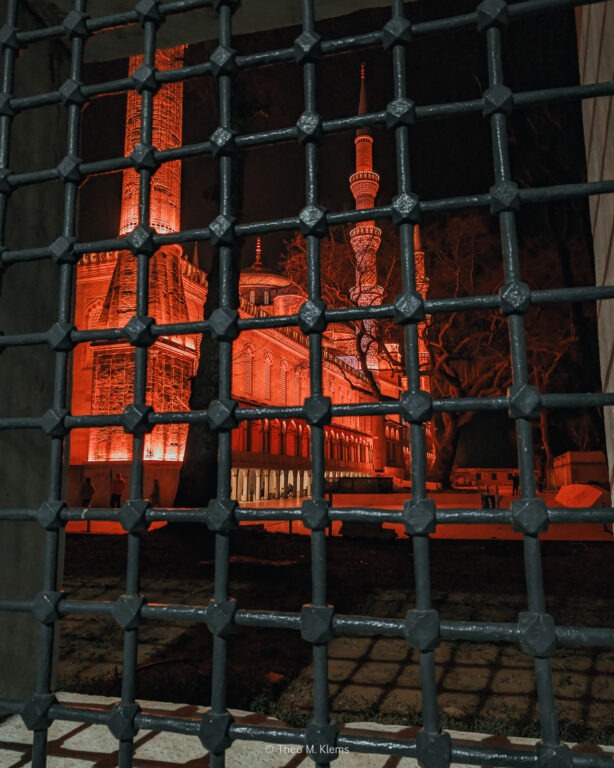 Blick durch ein Gitter auf rot beleuchteten Innenraum in Istanbul