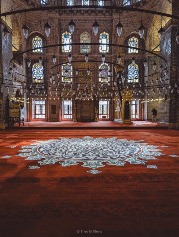 Gebetsraum einer Moschee in Istanbul mit Teppich, Fenstern und hängenden Lampen