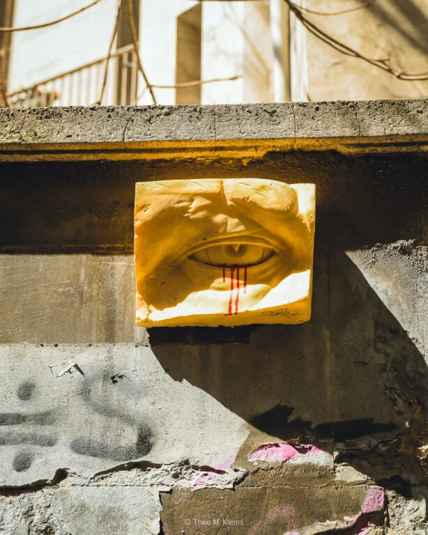 Streetart eines Auges mit roten Farbtropfen an einer rauen Hauswand in Istanbul