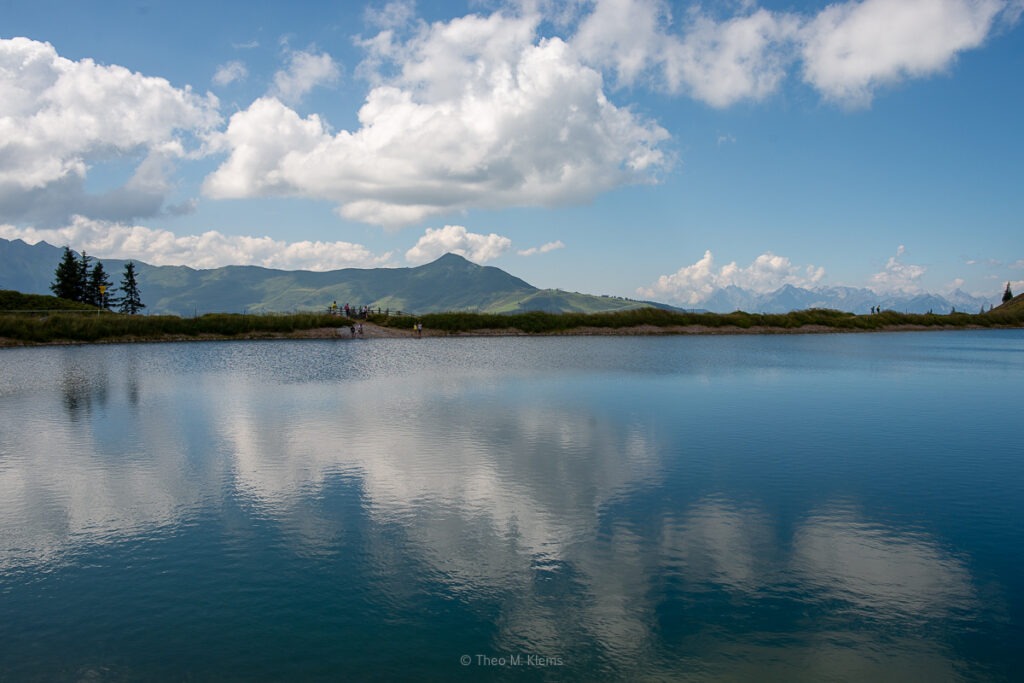 Bergsee in Tirol mit Spiegelung von Wolken und Bergen